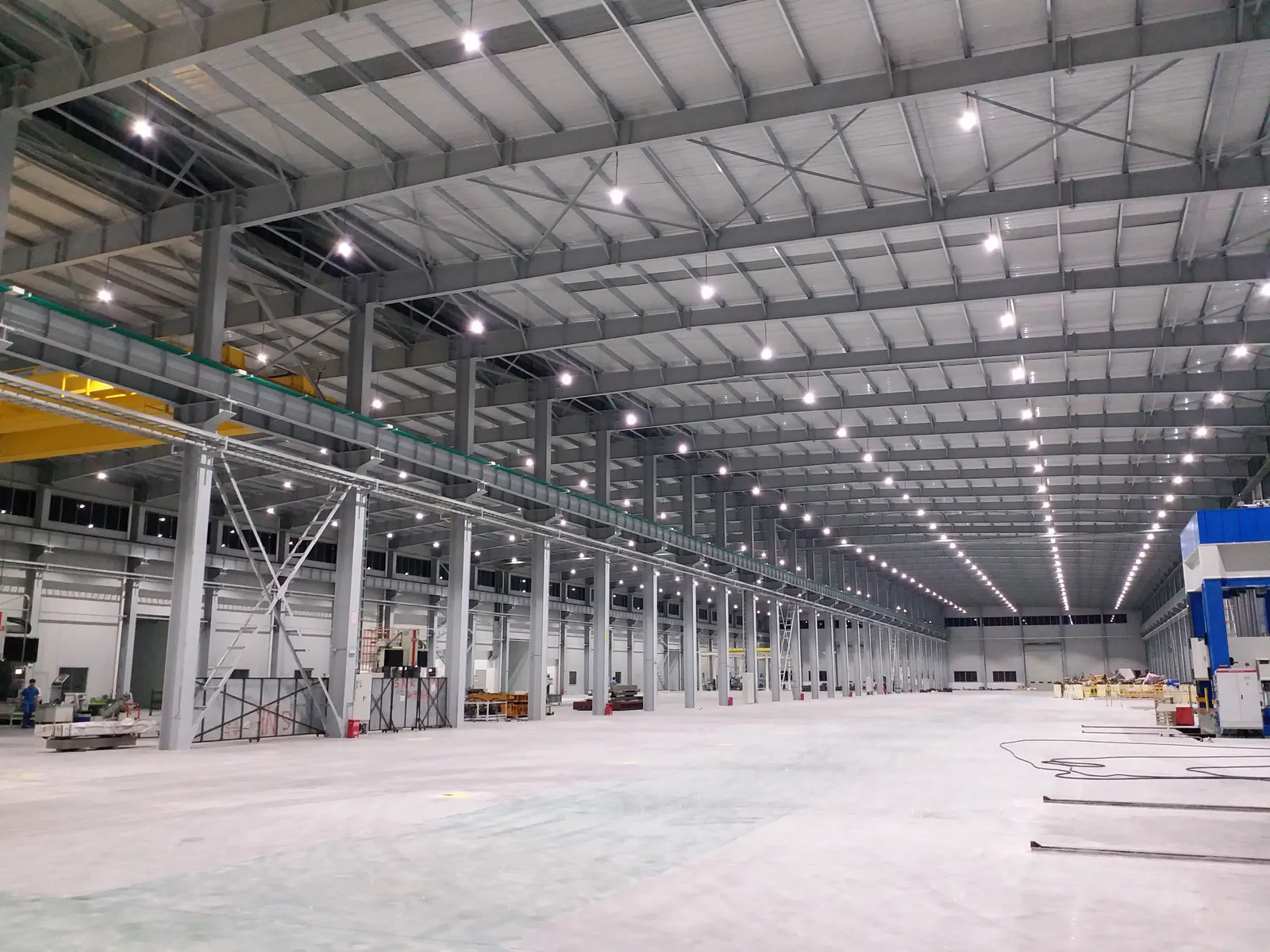 Rows of round high-bay lighting across a large industrial factory